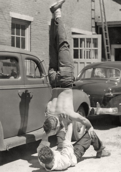 A photo of a gay couple doing handstands.