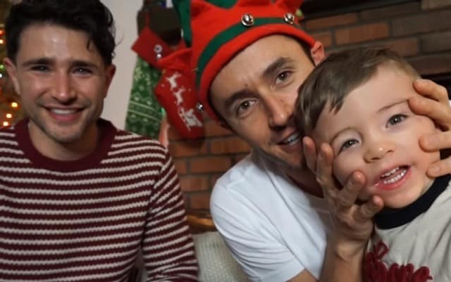 This is a photo of Matt Dallas , his husband Blue Hamilton and their new son.