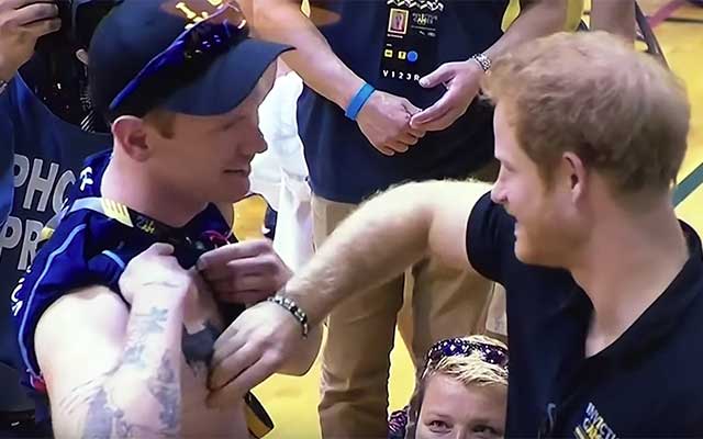 This is a photo of Prince Harry pinching a nipple.