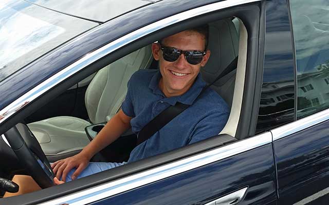 Gay guy in Tesla car.