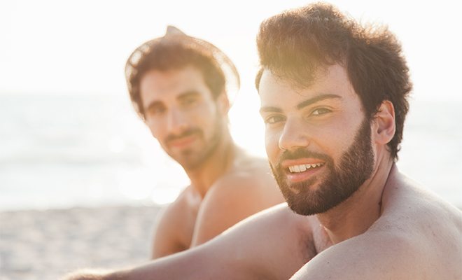 Gay men sitting on the beach