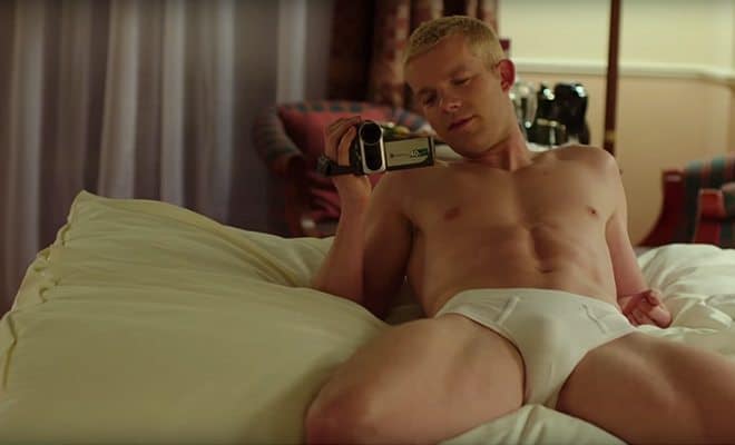 Russell Tovey laying on a bed in his underwear