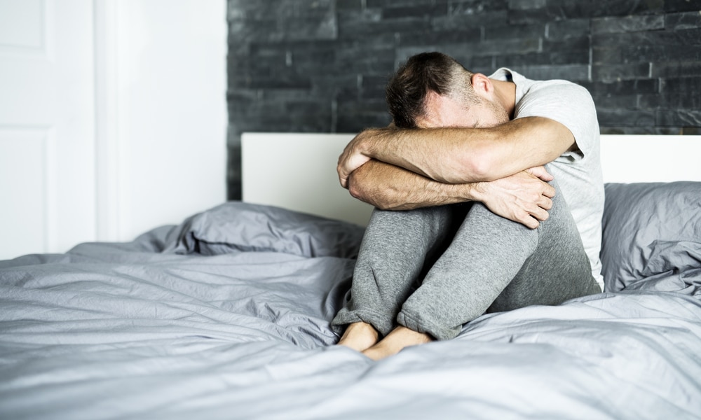 Anxious man sitting on a bed