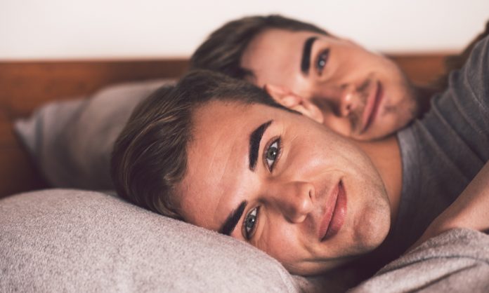Young gay couple in bed