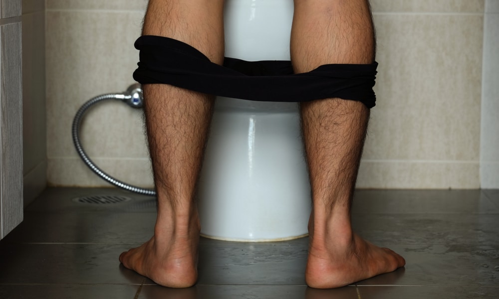 Man standing at a urinal.