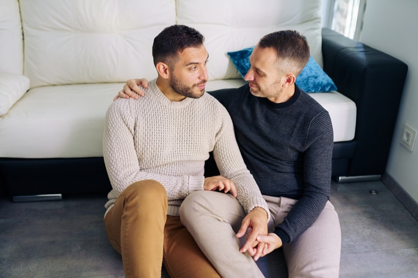 same sex male couple sitting on floor together