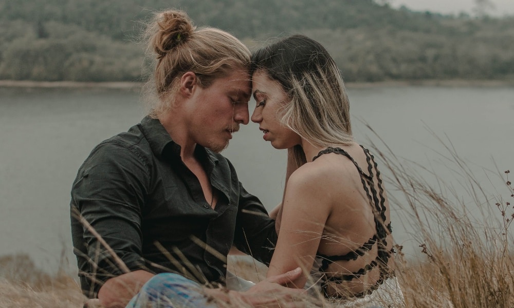 A cishet couple sitting in a field