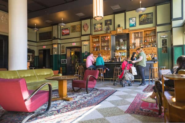 Ace Hotel Bar in New Orleans with several guests sitting at the bar in daytime.