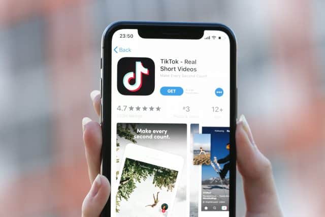 TikTok application icon on Apple iPhone X screen close-up. TikTok icon.