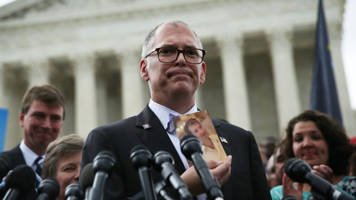 Plaintiff Jim Obergefell holds a photo of his late husband John Arthur as he speaks to members of the media after the U.S. Supreme Court handed down a ruling regarding same-sex marriage June 26, 2015 outside the Supreme Court in Washington, DC. The high court ruled that same-sex couples have the right to marry in all 50 states.