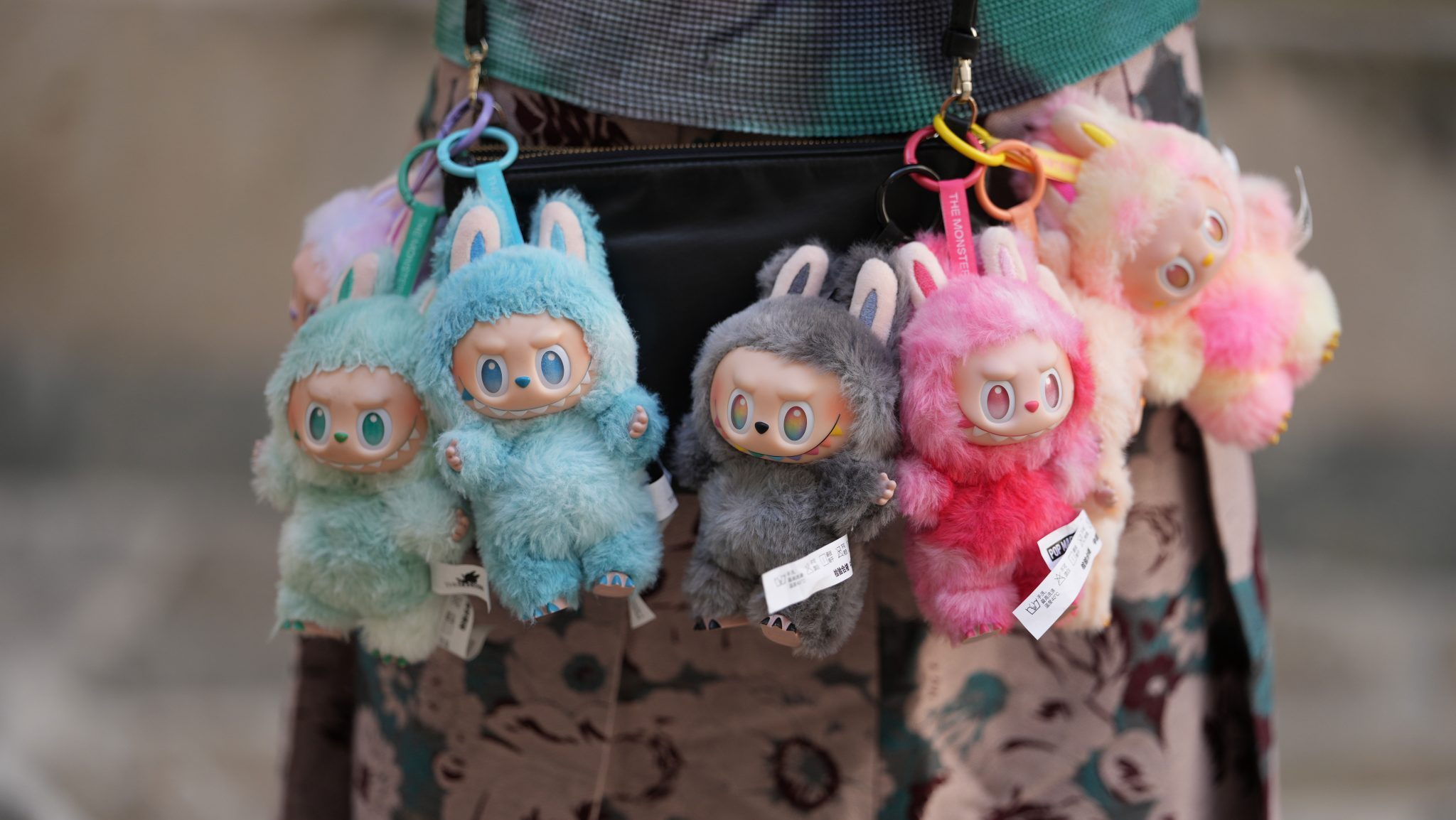 Close-up detail view of seven Labubu monsters / charms / dolls / plus from "Big Into Energy" collection : Loyalty, Happiness, Luck, Hope, Serenity, Love an Secret, during a street style fashion photo session, on June 12, 2025 in Paris, France.