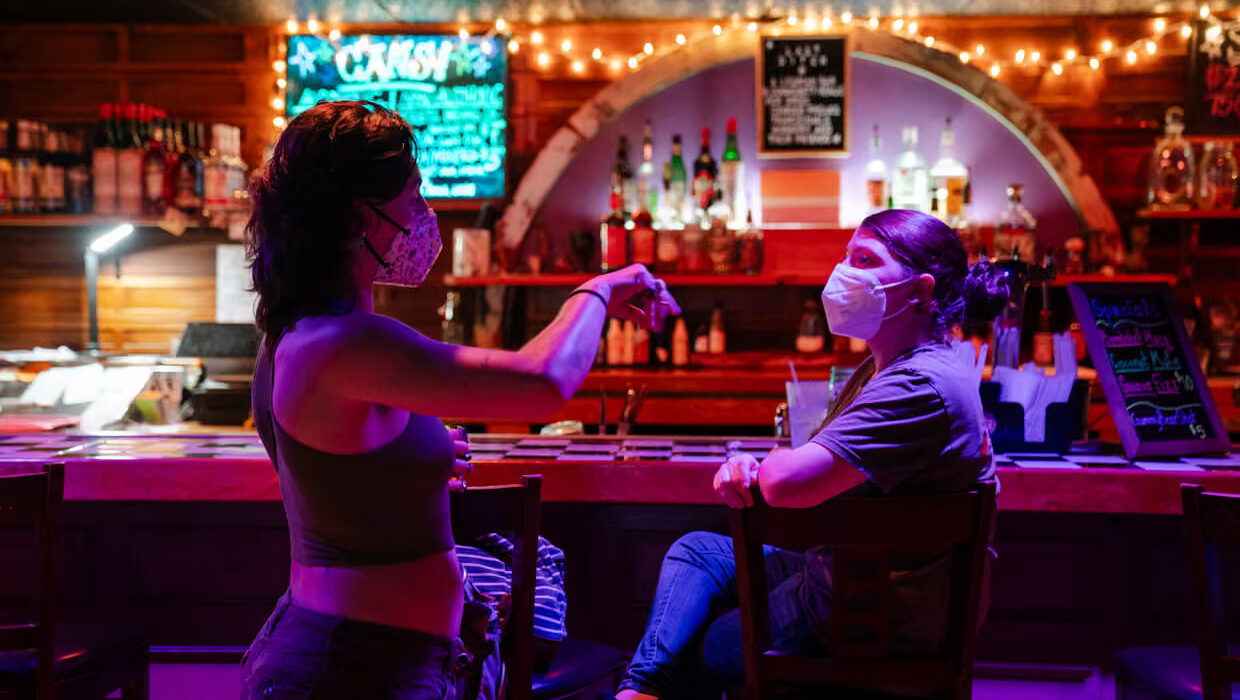 Jackie Matellian (left), the owner of Last Ditch Bar and Arts Venue, talks with a patron at the bar in Greenfield, Massachusetts, last week.