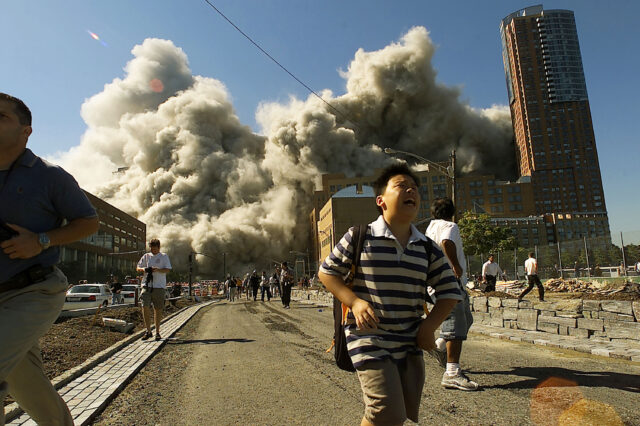 People run away as the North Tower of World Trade Center collapses after a hijacked airliner hit the building September 11, 2001 in New York City.  