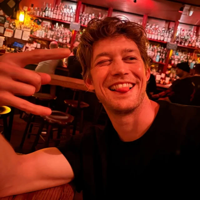 Joe Alwyn flashes a cheeky grin and throws up a rock-and-roll hand sign during dinner with Mary Beth Barone in New York City.
