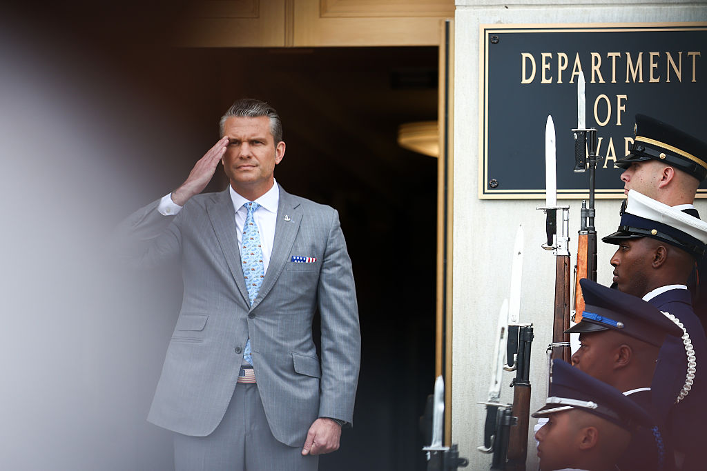Pete Hegseth saluting beside an honor guard at the Pentagon in October 2026
