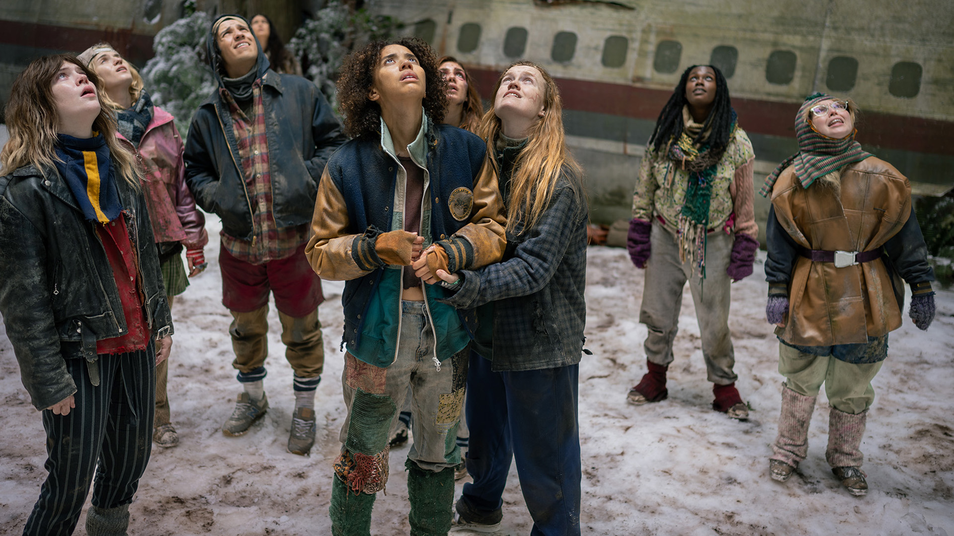 L-R: Sophie Thatcher as Teen Natalie, Jenna Burgess as Teen Melissa, Kevin Alves as Teen Travis, Courtney Eaton as Teen Lottie, Jasmin Savoy Brown as Teen Taissa, Sophie Nélisse as Teen Shauna, Liv Hewson as Teen Van, Nia Sondaya as Teen Akilah and Samantha Hanratty as Teen Misty in Yellowjackets, episode 8, season 4, streaming on Paramount+, 2026. Photo Credit: Eric Milner/Paramount+.
