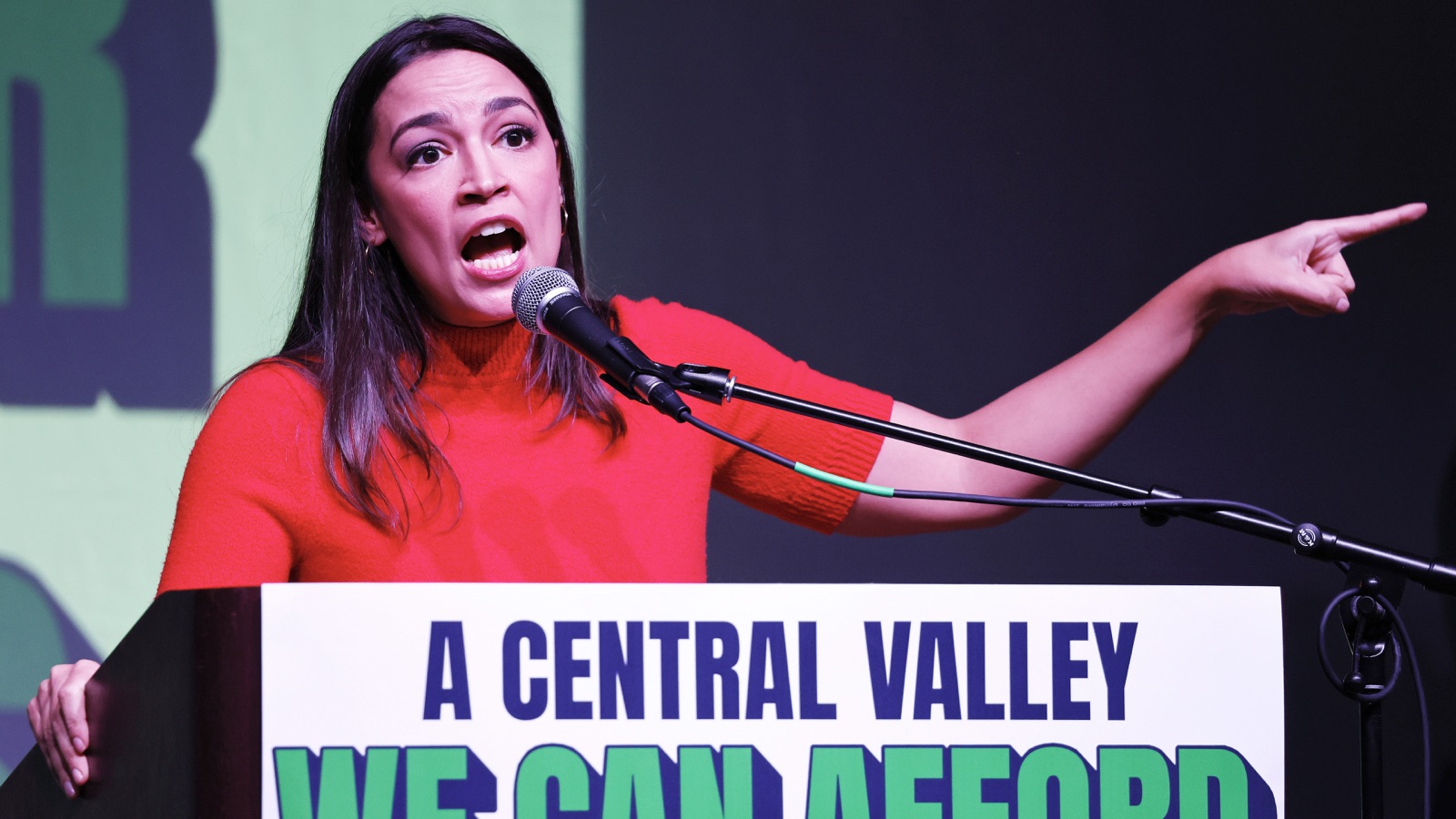 Alexandria Ocasio-Cortez speaks into a microphone and points during a Bakersfield campaign rally.